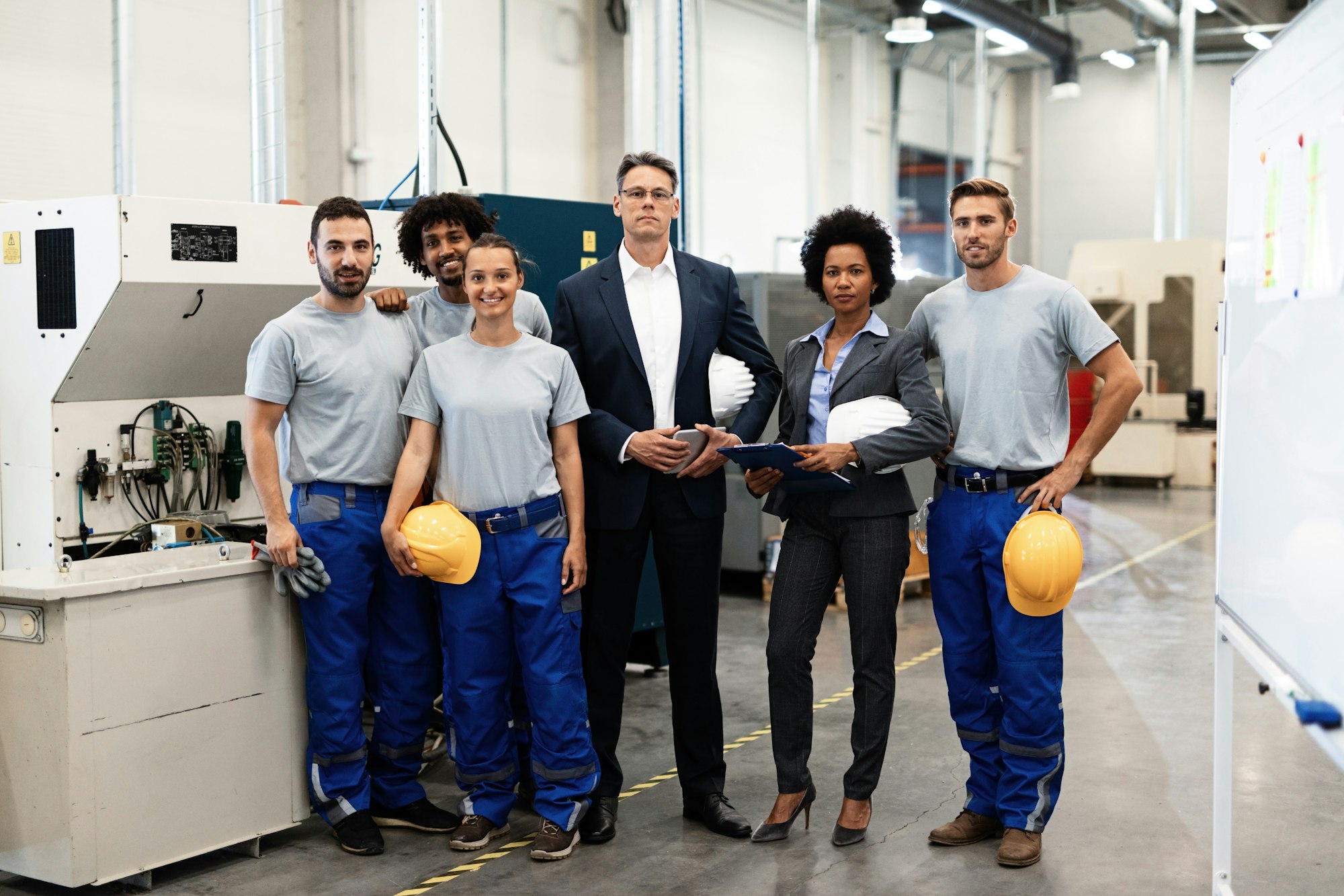 Portrait of company leaders and their employees in industrial plant.